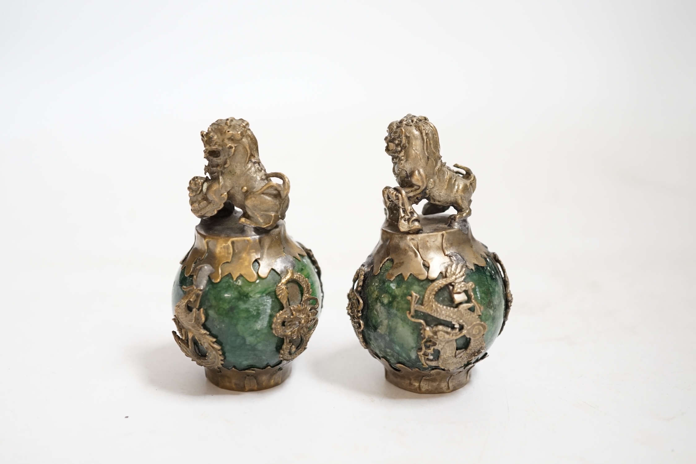 A pair of Chinese Buddhist lion hardstone and brass mounted paperweights, 7cm high., Condition - fair